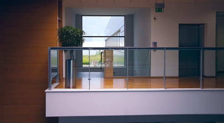 Office interior with a glass balustrade overlooking a double-volume space