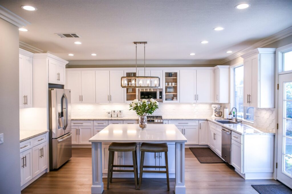 White kitchen with a central island and pendant lights