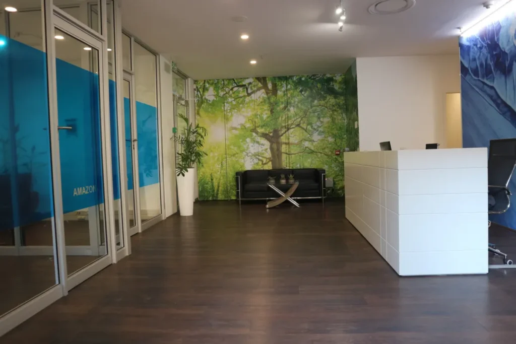 White reception desk beside glass-partitioned offices